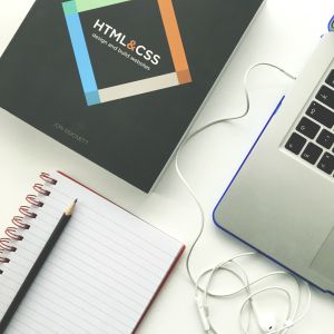 Caderno com um lápis livro de html e um computador