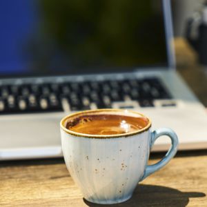 Computador e uma caneca de café